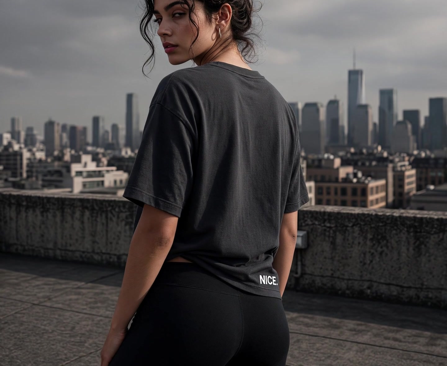 Frau auf einem Betondach, oversized Asphalt-Tee, Blick über die Stadt